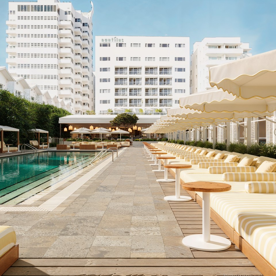 Outdoor lounge terrace with pool, umbrellas, and greenery